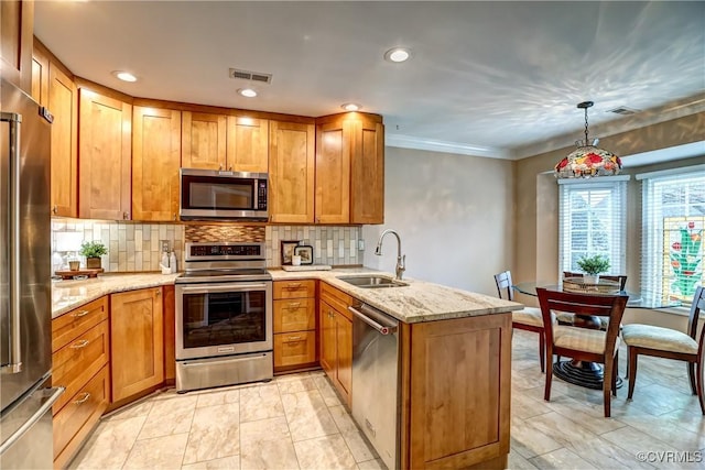 kitchen featuring a peninsula, appliances with stainless steel finishes, decorative backsplash, and a sink