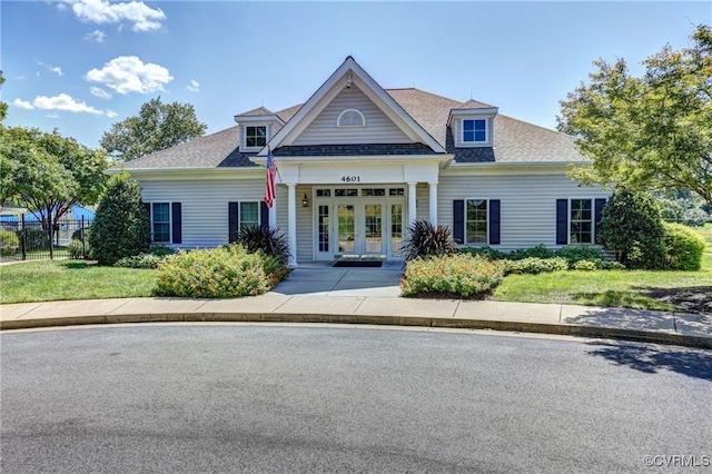 view of front facade featuring a shingled roof, fence, and french doors