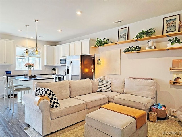 living room featuring visible vents, wood finished floors, and recessed lighting