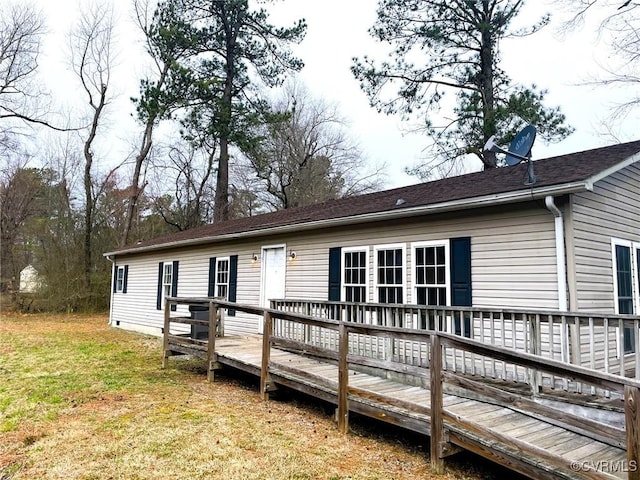 rear view of house featuring a lawn and a wooden deck