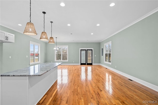 616 N 37th St, Richmond, VA 23223 - kitchen with ornamental molding, light wood finished floors, white cabinetry, light stone counters, and decorative light fixtures