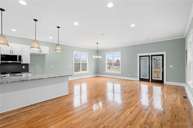 616 N 37th St, Richmond, VA 23223 - unfurnished living room with light wood-style flooring, a chandelier, crown molding, and recessed lighting