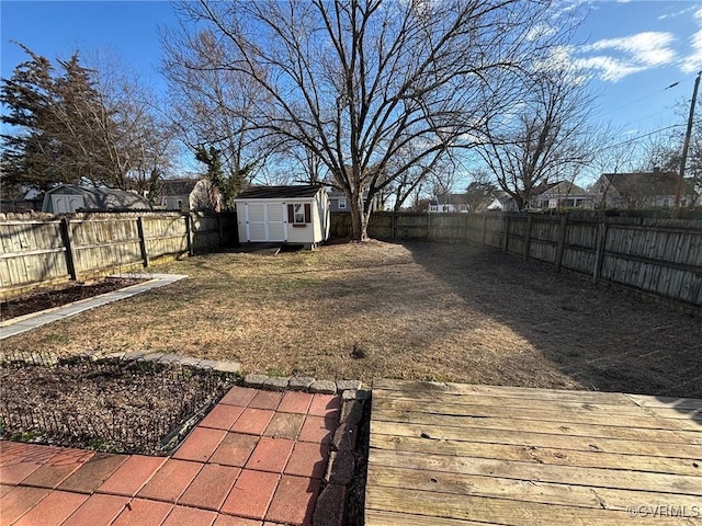 view of yard with an outbuilding, a fenced backyard, and a shed