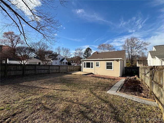 back of house with a patio area, a fenced backyard, and a lawn