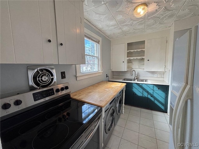 kitchen with butcher block counters, an ornate ceiling, stainless steel range with electric stovetop, open shelves, and a sink