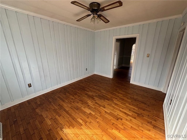 empty room featuring crown molding, ceiling fan, and wood finished floors