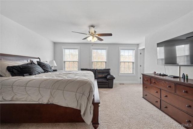 bedroom with ceiling fan, baseboards, and light colored carpet