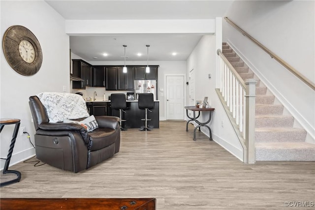 living area featuring light wood-style floors, recessed lighting, stairway, and baseboards