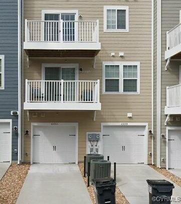 back of house featuring a garage, driveway, and central air condition unit