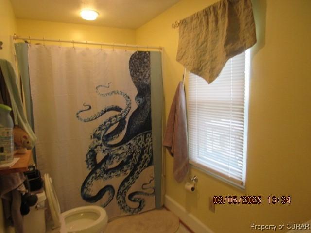 bathroom featuring toilet and a shower with shower curtain