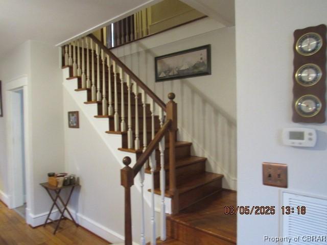 stairs featuring wood finished floors and baseboards