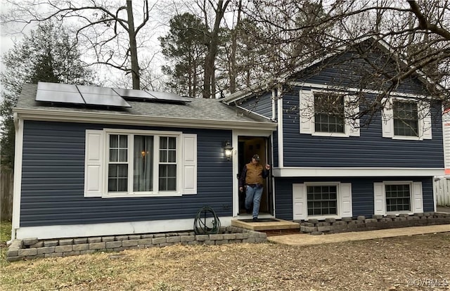 split level home featuring roof mounted solar panels