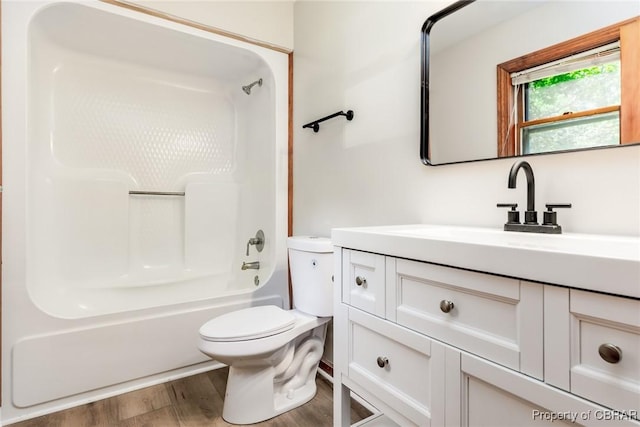 bathroom with vanity, bathtub / shower combination, wood finished floors, and toilet