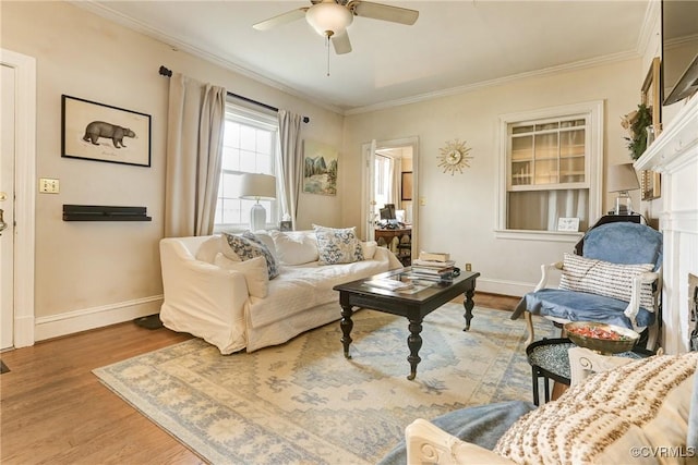 living room with baseboards, ceiling fan, wood finished floors, and crown molding