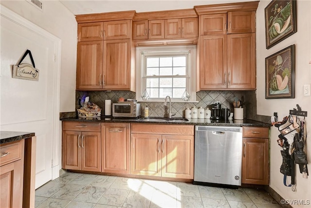 kitchen featuring visible vents, dishwasher, dark stone countertops, marble finish floor, and a sink