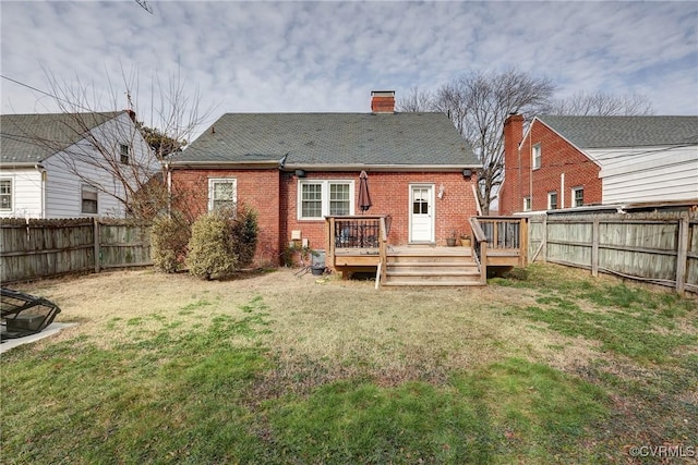 back of house with brick siding, a yard, a fenced backyard, and a wooden deck