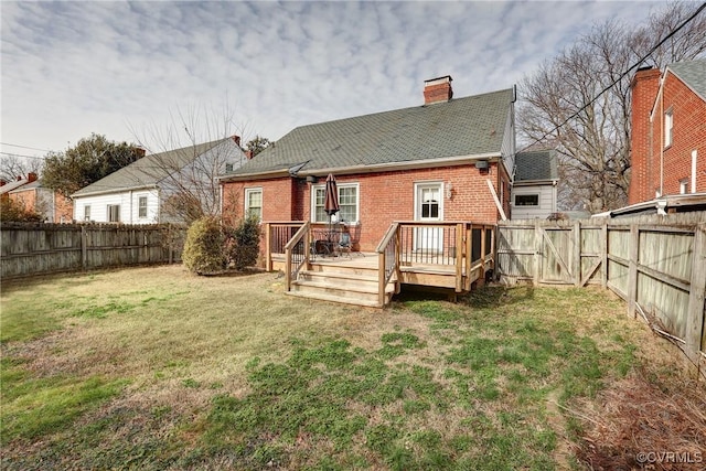 back of house featuring a wooden deck, a fenced backyard, a lawn, and brick siding