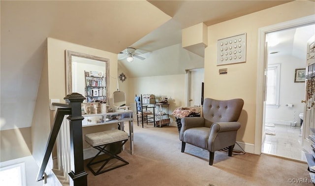 living area featuring lofted ceiling, carpet flooring, ceiling fan, and an upstairs landing