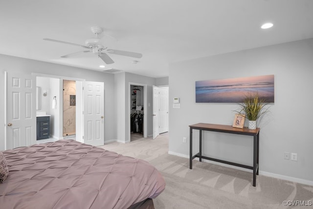 bedroom featuring connected bathroom, recessed lighting, light colored carpet, baseboards, and a spacious closet