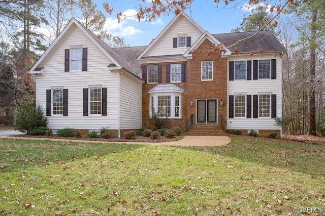 view of front facade featuring a front yard, brick siding, and entry steps