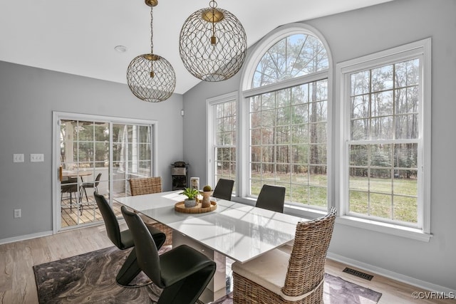 dining area featuring visible vents, baseboards, and wood finished floors