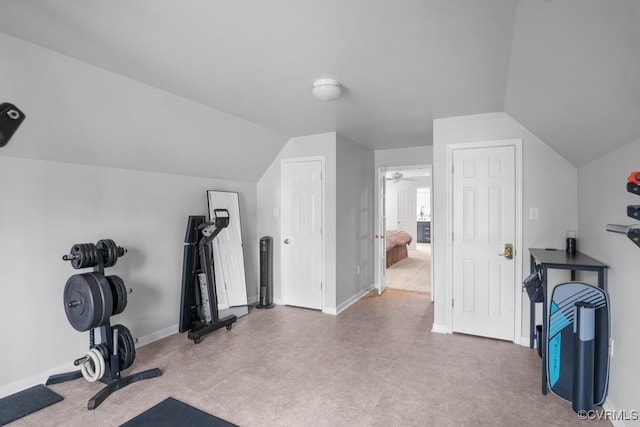 workout area with lofted ceiling and baseboards