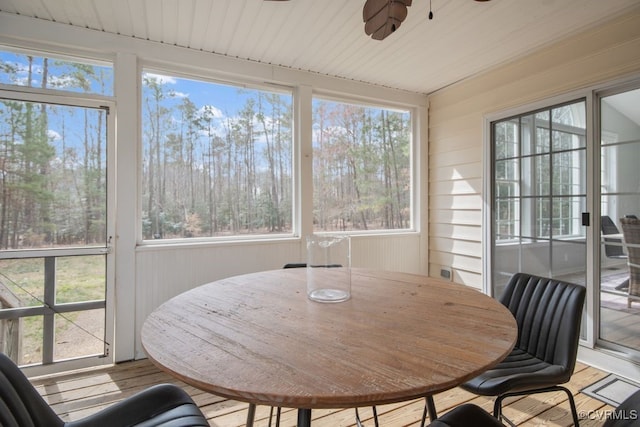 sunroom featuring wood ceiling and a ceiling fan