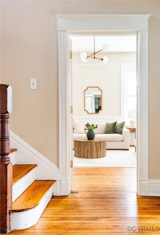 interior space featuring a notable chandelier, stairs, and wood finished floors