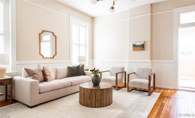 living room with wood-type flooring and a wainscoted wall