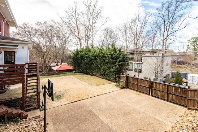 view of patio featuring driveway and fence