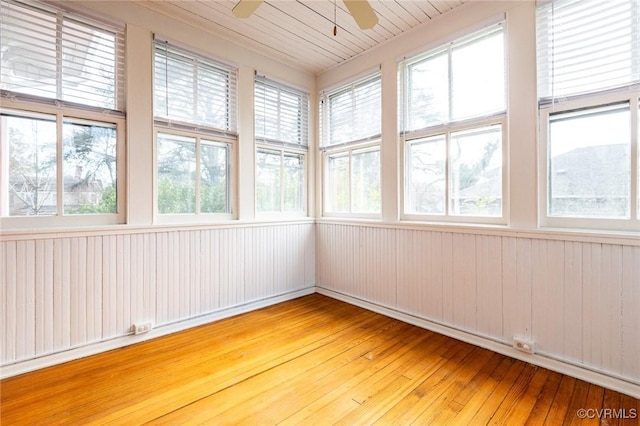 unfurnished sunroom featuring a ceiling fan