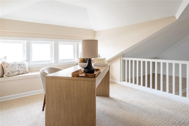 interior space with light carpet, vaulted ceiling, and baseboards