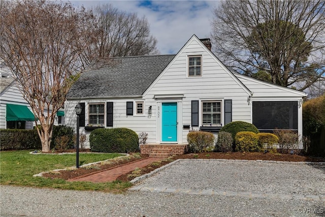 bungalow-style home with a front yard, roof with shingles, and a chimney