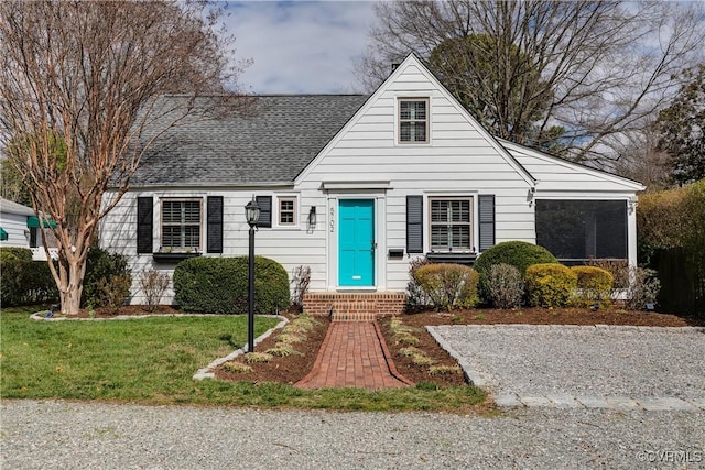 bungalow with a front yard and a shingled roof