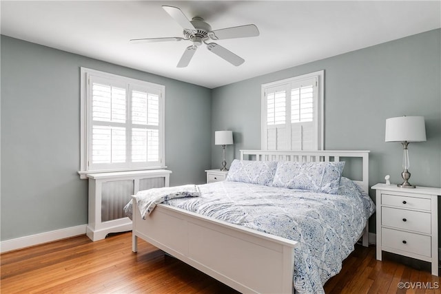 bedroom with a ceiling fan, baseboards, and wood finished floors