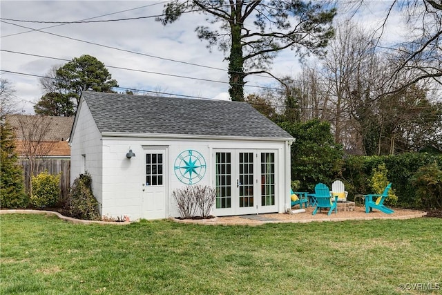 view of outbuilding featuring french doors, a fire pit, an outdoor structure, and fence