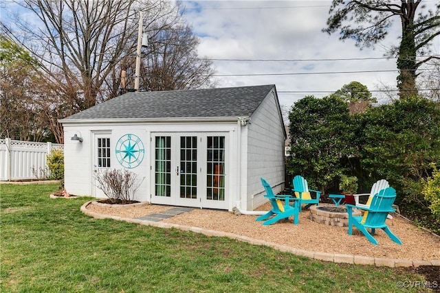 view of outbuilding featuring an outdoor structure, fence, and an outdoor fire pit