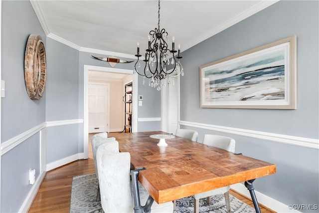 dining space featuring wood finished floors, baseboards, and ornamental molding