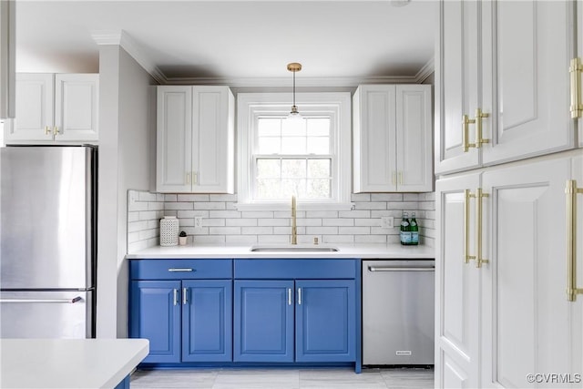 kitchen with a sink, blue cabinetry, backsplash, stainless steel appliances, and light countertops