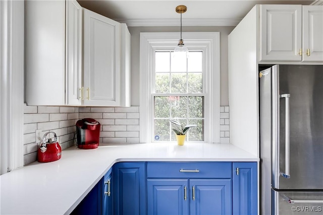 kitchen featuring crown molding, blue cabinetry, tasteful backsplash, and high end refrigerator