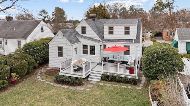 back of property featuring a lawn, an outdoor living space, fence, roof with shingles, and a chimney