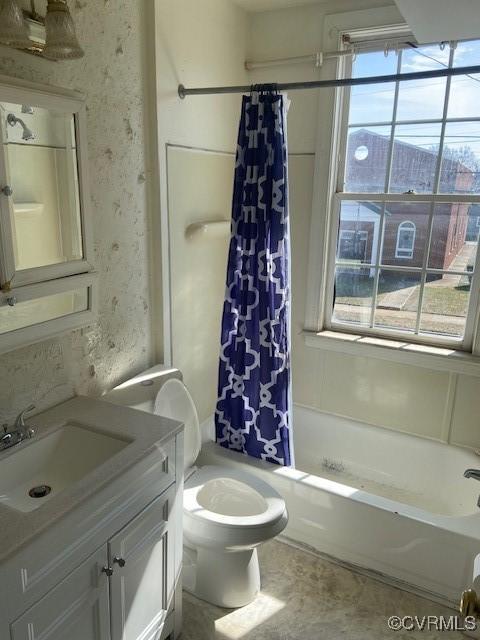 bathroom featuring plenty of natural light, vanity, toilet, and wallpapered walls