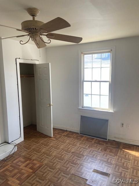 unfurnished bedroom featuring a closet, ceiling fan, and baseboards