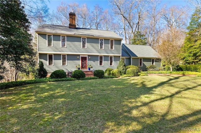 colonial inspired home with a front yard and a chimney