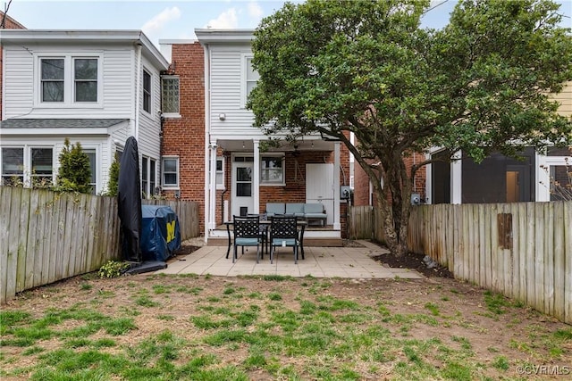 back of house featuring brick siding, a patio area, and a fenced backyard