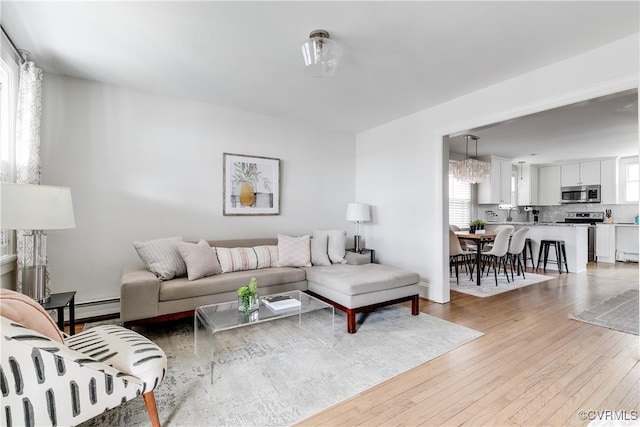 living room featuring a baseboard heating unit and light wood finished floors