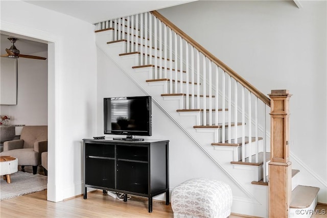 stairway with baseboards and wood finished floors