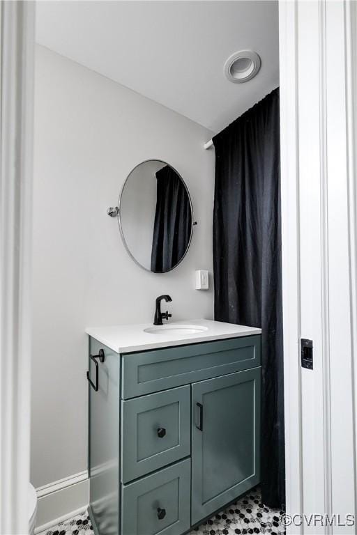 bathroom featuring toilet, vanity, and baseboards