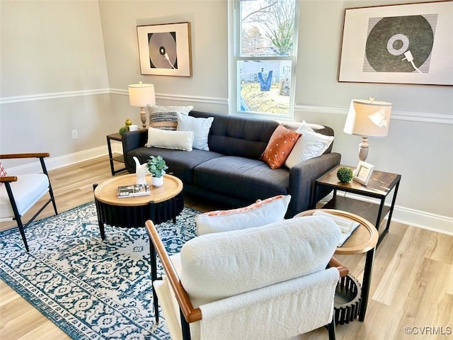 living area with baseboards and wood finished floors