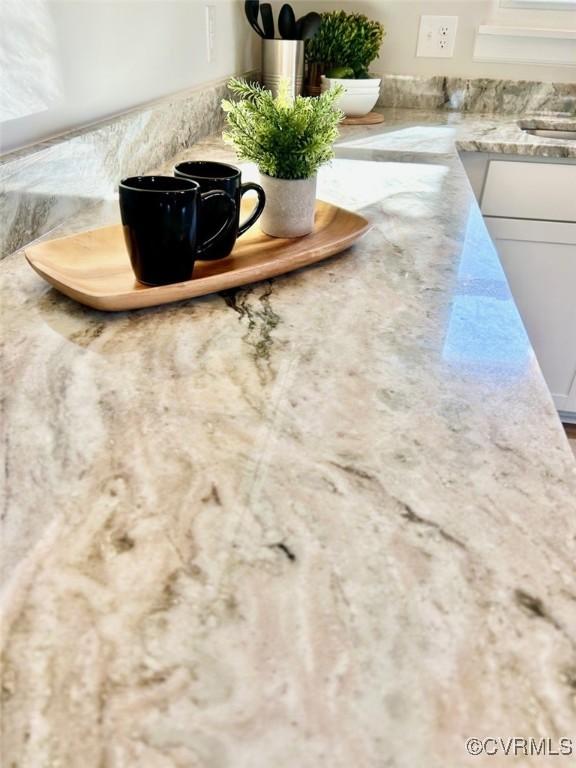 details with light stone countertops and white cabinets